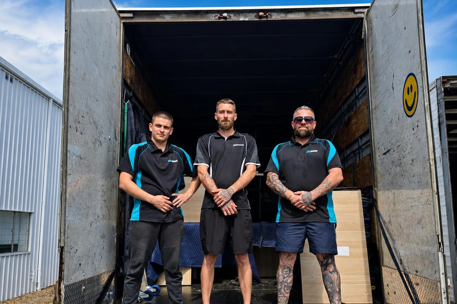 The Mint Movers team of three at the back of a loaded truck on a commercial move